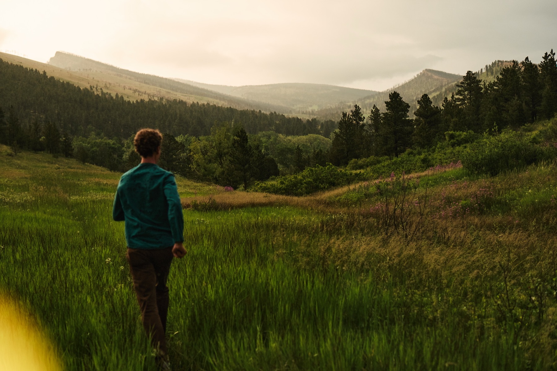 Mark Andreas walking, mid-stride, in open landscape.